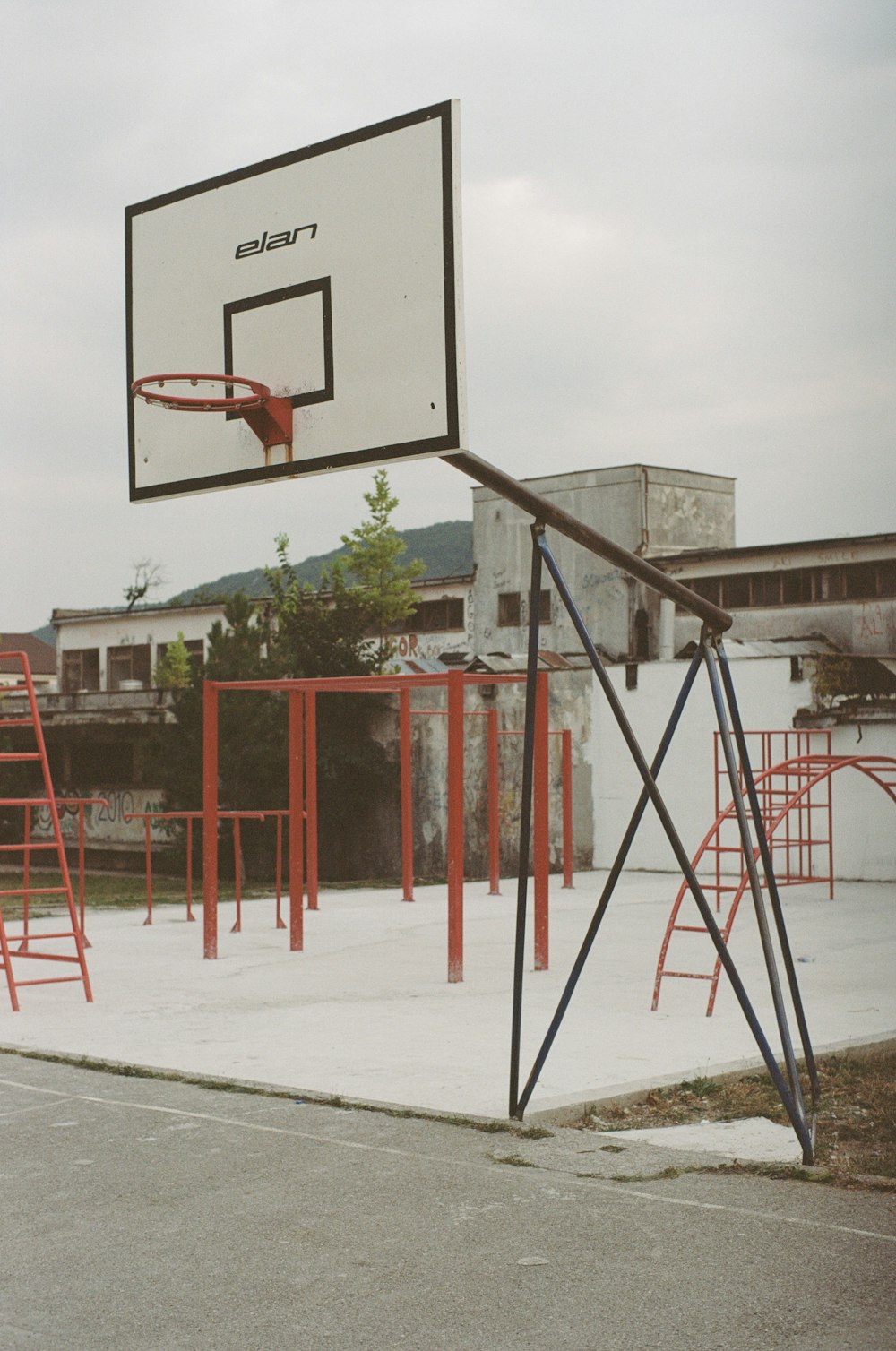 a basketball hoop with a basketball in the middle of a playground