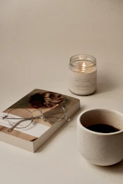 A cozy scene with headphones resting on an open book beside a warm cup of tea.