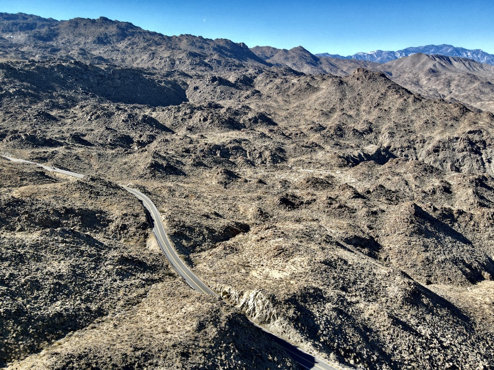 an aerial view of a winding road in the mountains