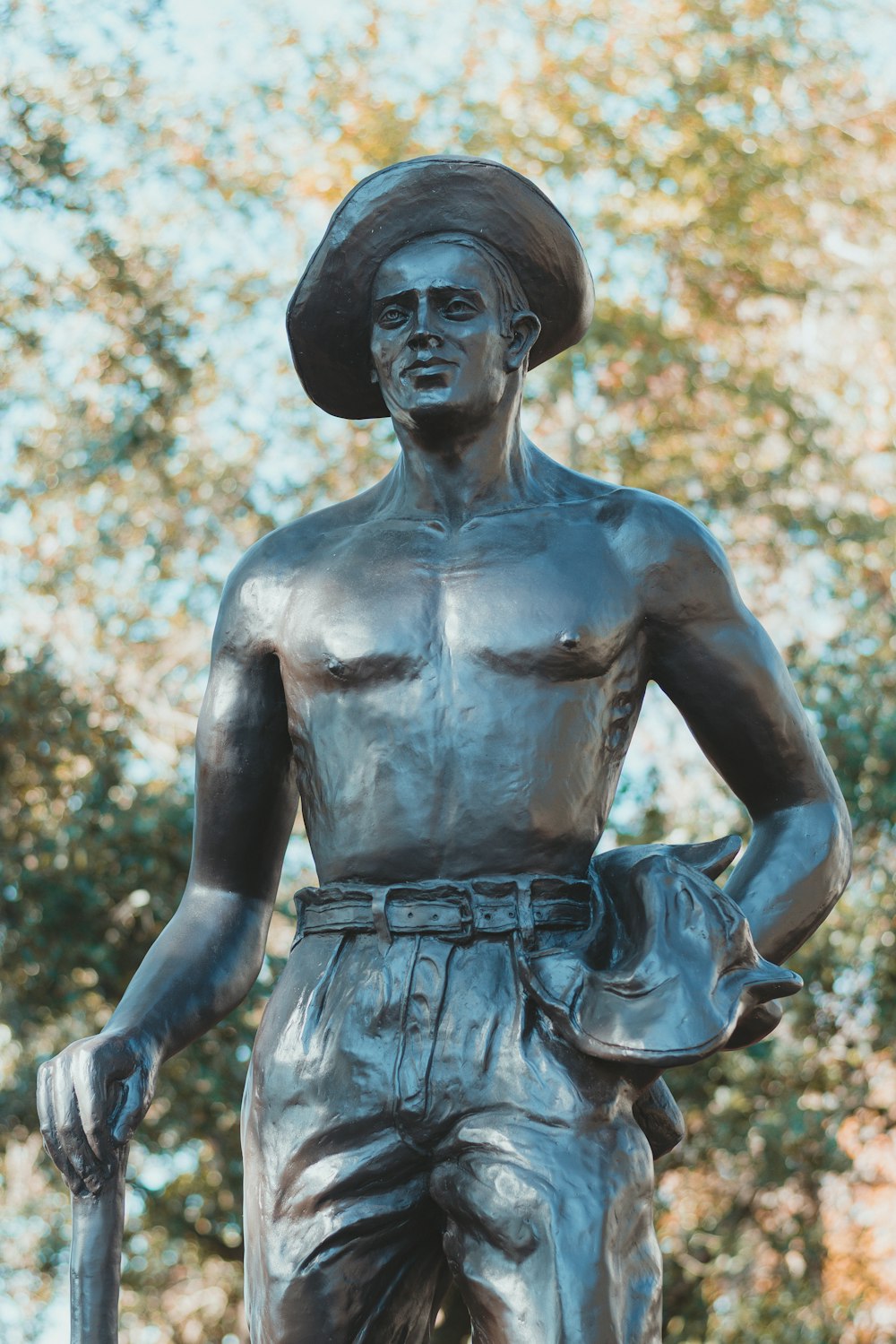 une statue d’un homme avec un chapeau et une canne