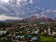 An aerial drone shot revealing Denver’s cityscape framed by the distant Rocky Mountains.