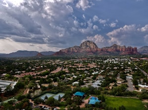 Aerial view of downtown Denver with skyscrapers framed by the Rocky Mountains in the background.