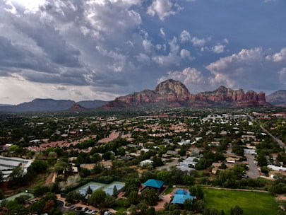 Aerial view of downtown Denver with skyscrapers framed by the Rocky Mountains in the background.