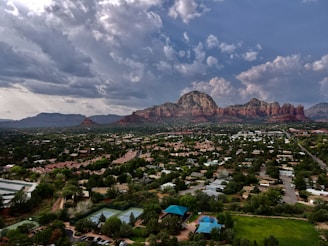 An aerial drone shot revealing Denver’s cityscape framed by the distant Rocky Mountains.