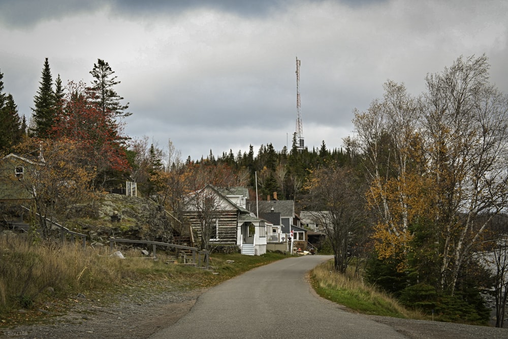 Una strada con una casa e una torre radio sullo sfondo