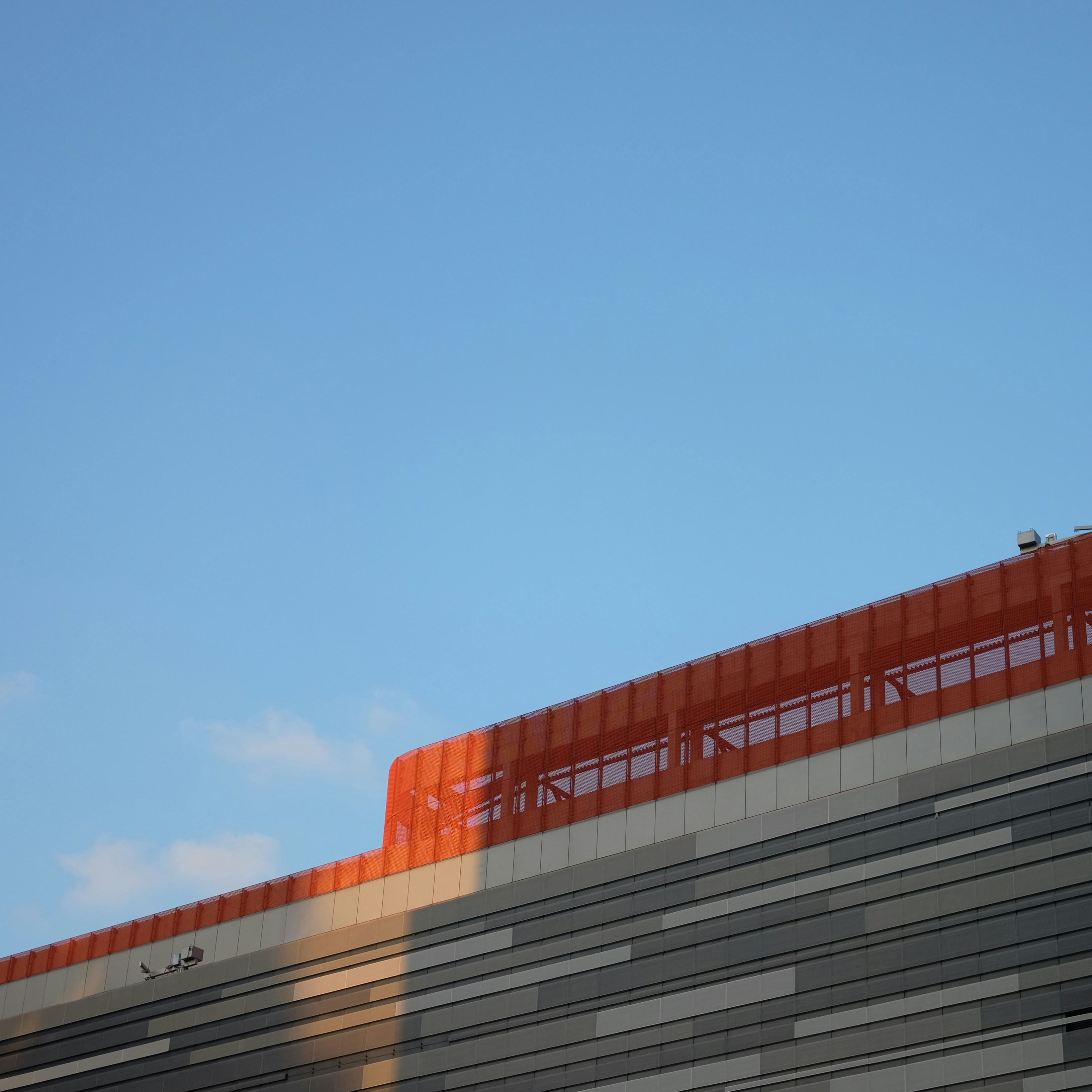 an airplane flying over a building with a sky background