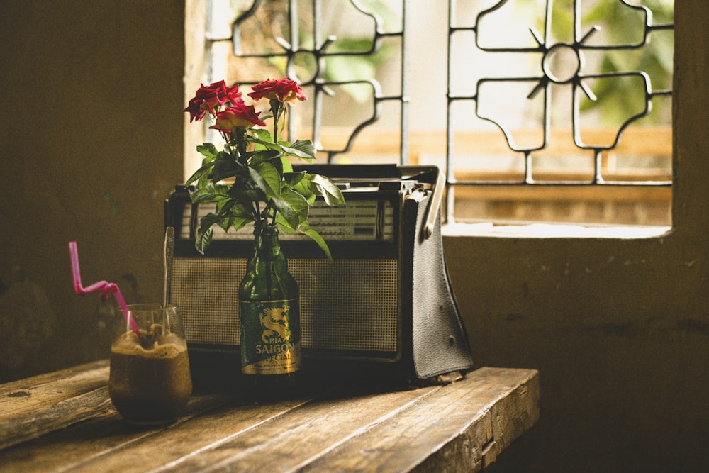 a radio sitting on a table next to a vase with flowers