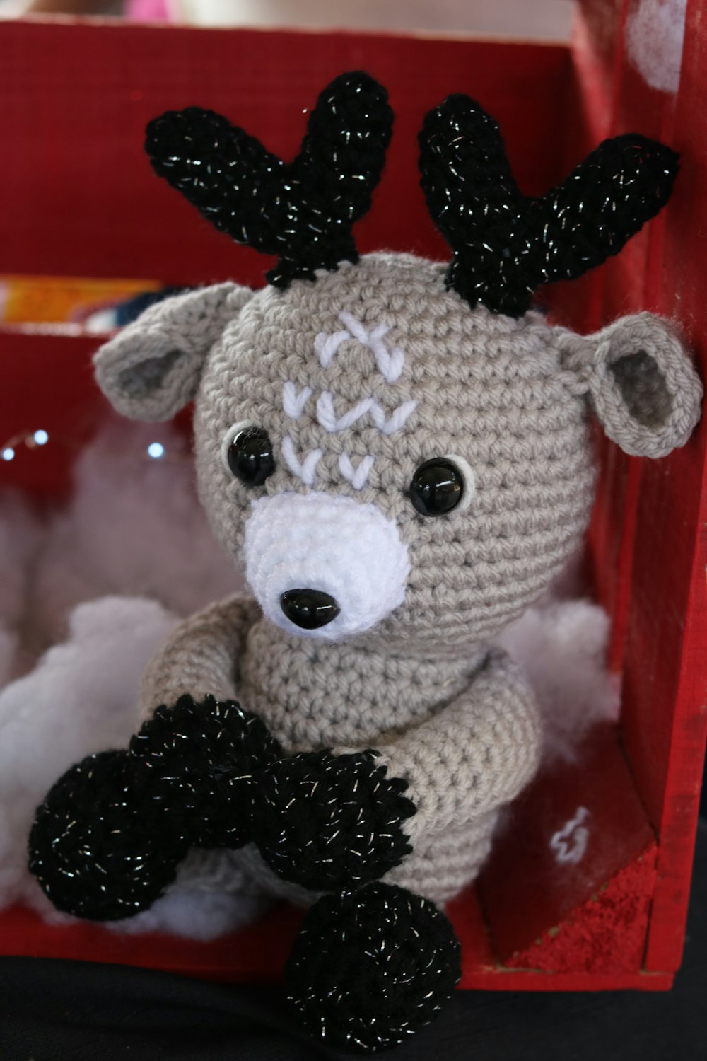 a crocheted stuffed animal in a red box