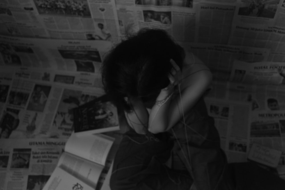 a woman sitting on the floor with her head in her hands