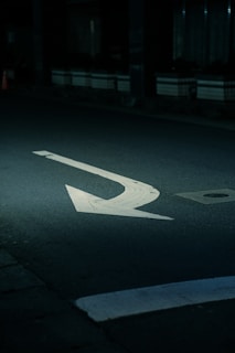 a street with a white arrow painted on it