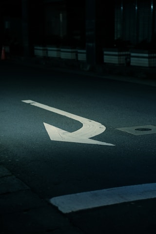 a street with a white arrow painted on it