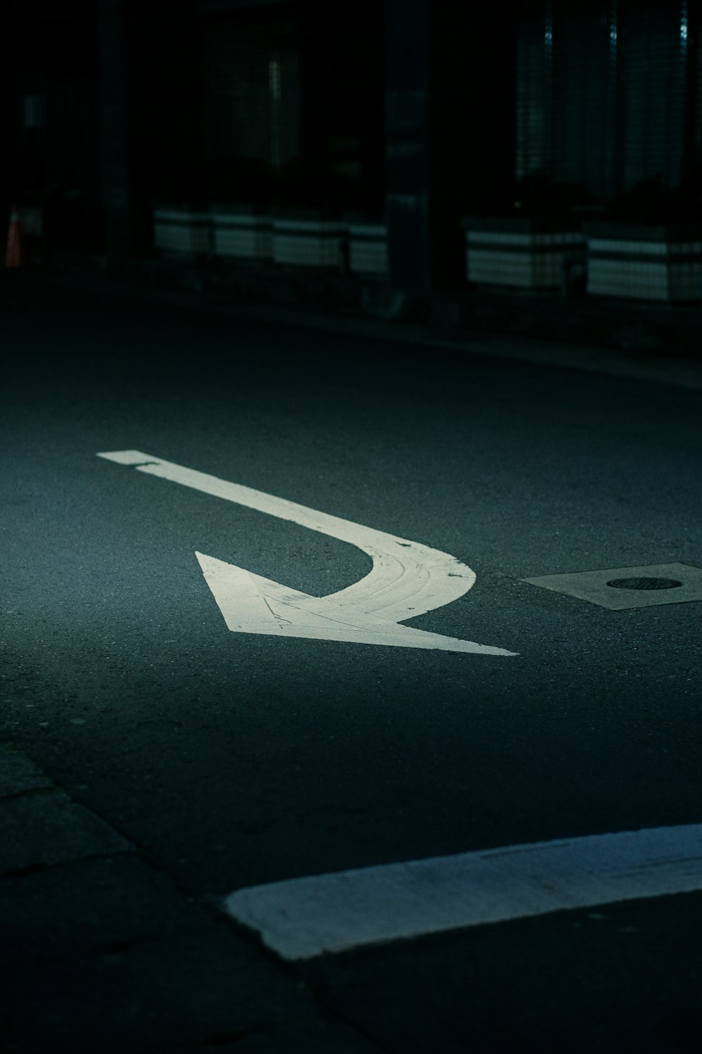 uma rua com uma seta branca pintada sobre ela