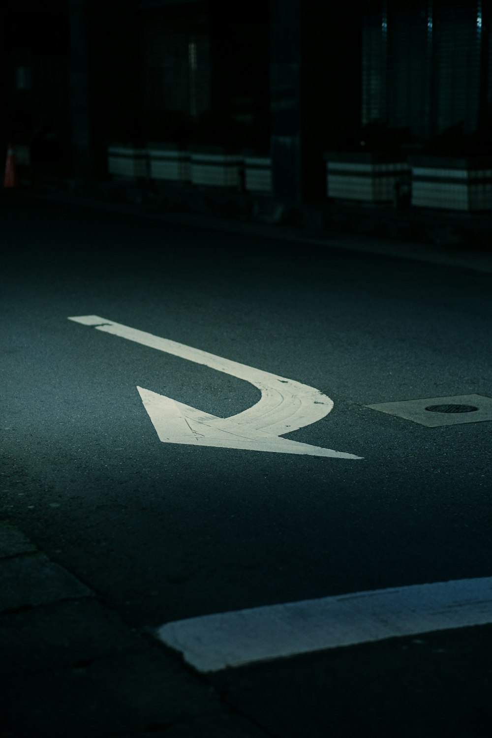 a street with a white arrow painted on it