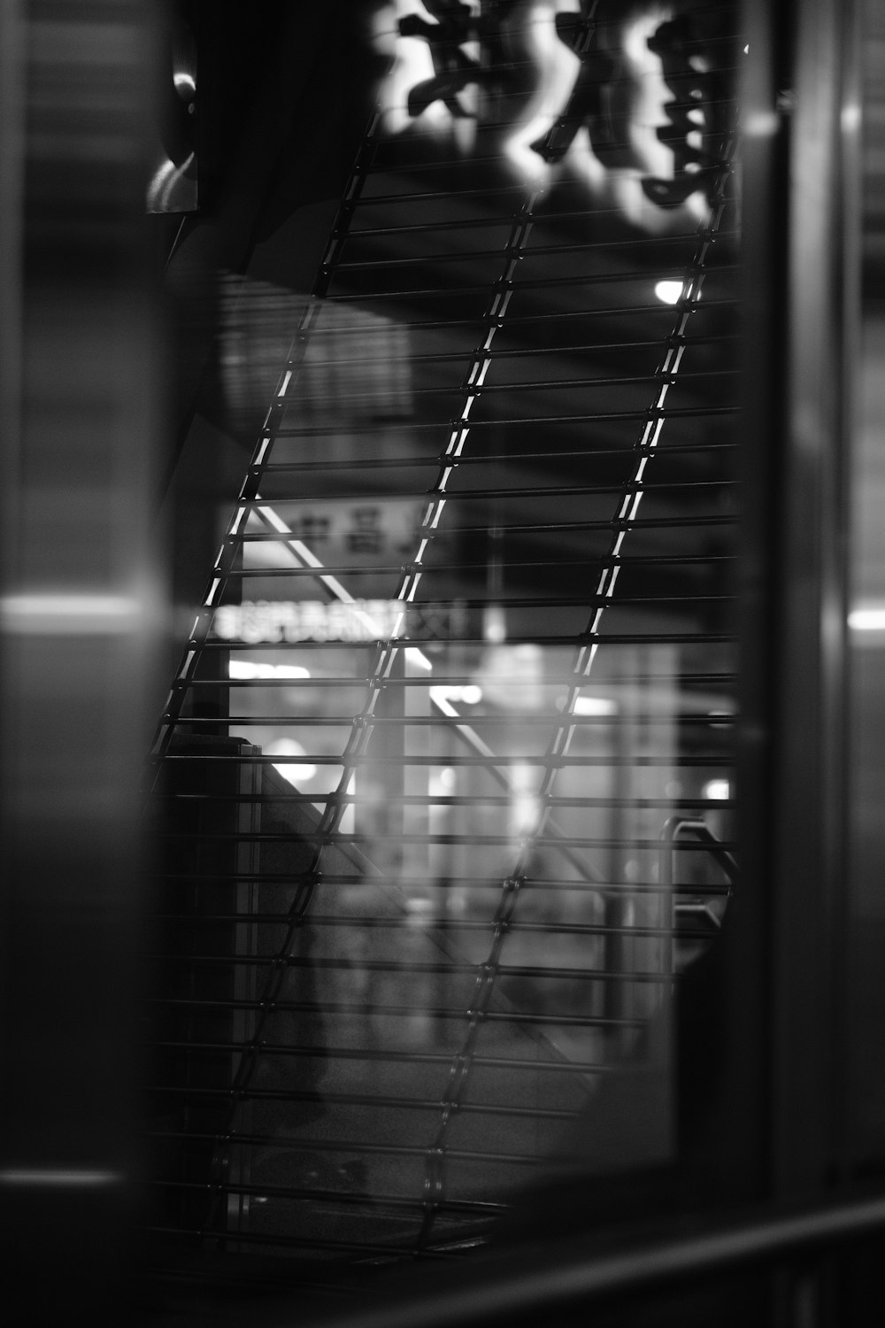 a black and white photo of a window with blinds