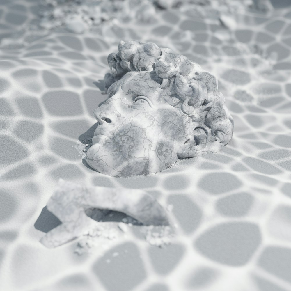 a sculpture of a man's head in a pool of water