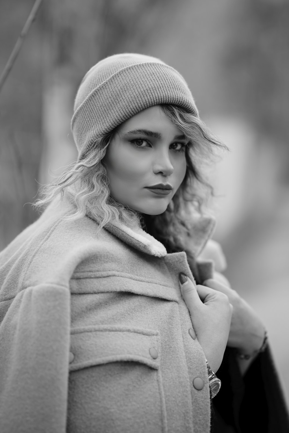 a black and white photo of a woman in a coat