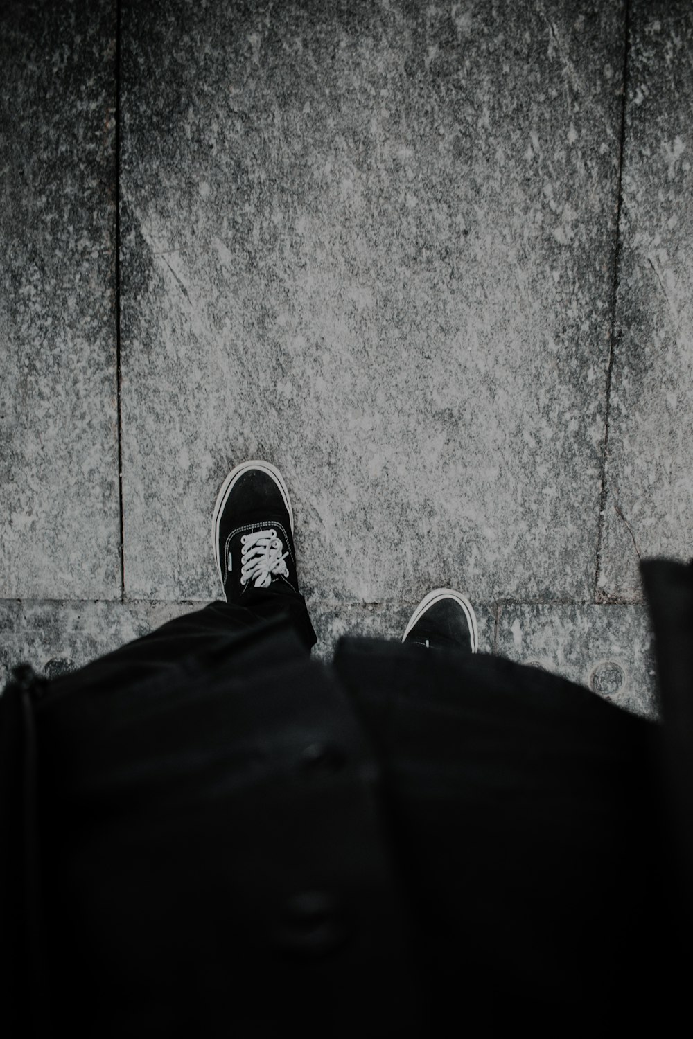 a person standing on a sidewalk with their feet up