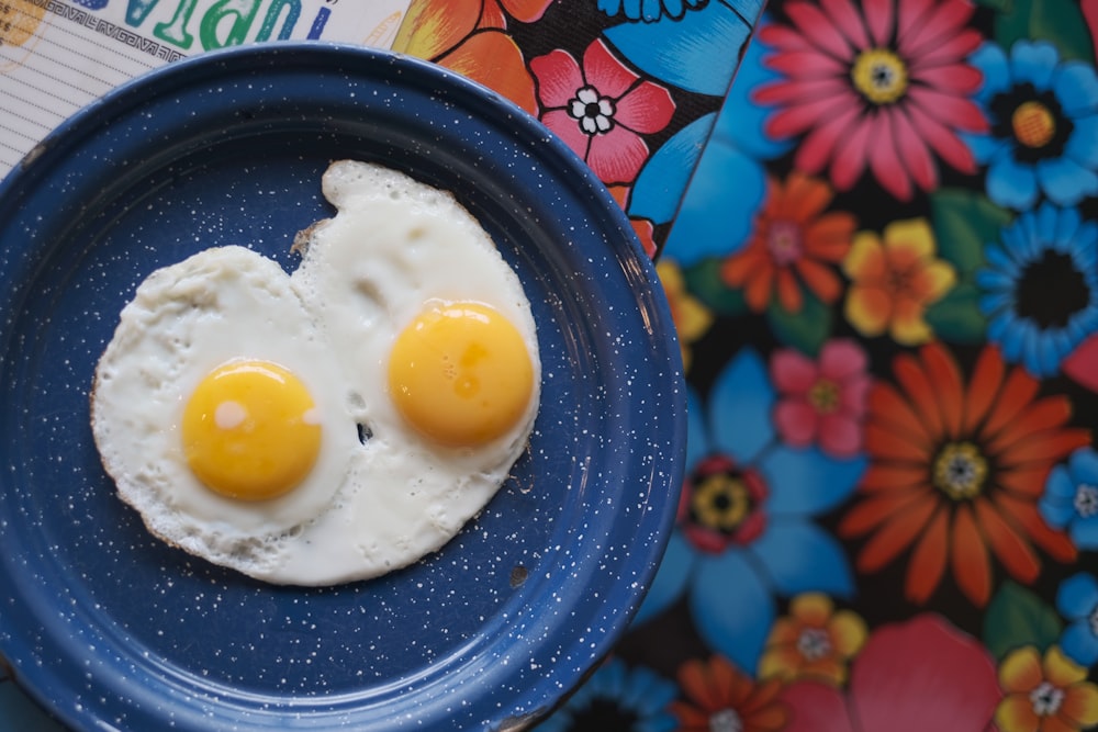 a blue plate topped with two fried eggs