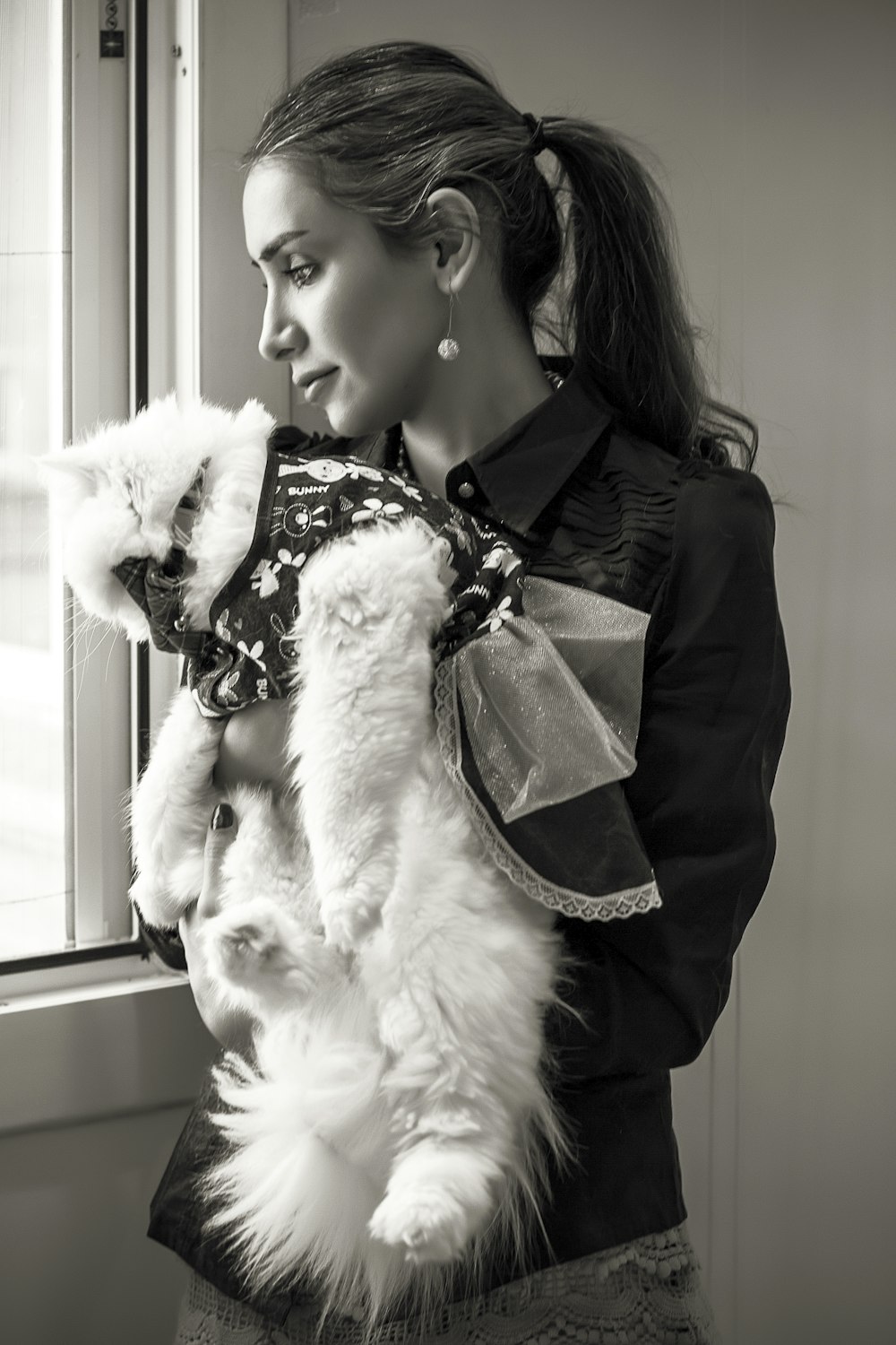 a woman holding a fluffy white dog in her arms