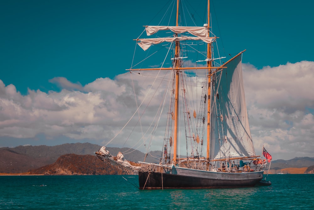 a large sail boat floating on top of a body of water