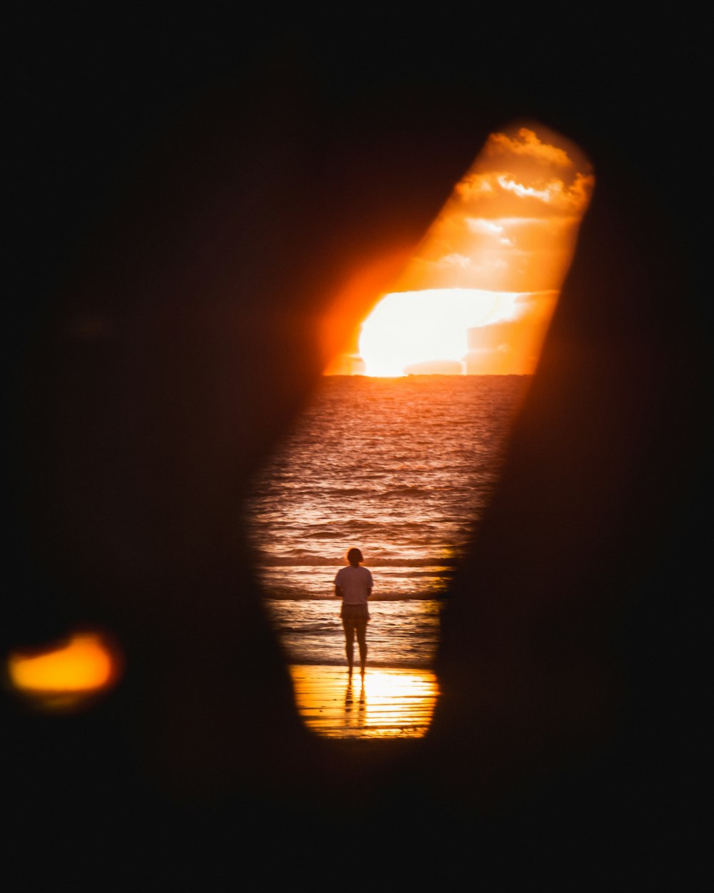 a person standing on a beach at sunset