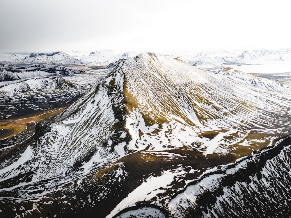 a mountain covered in snow and surrounded by mountains