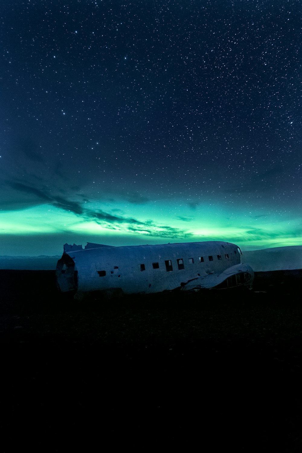 a plane sitting in the middle of a field under a night sky