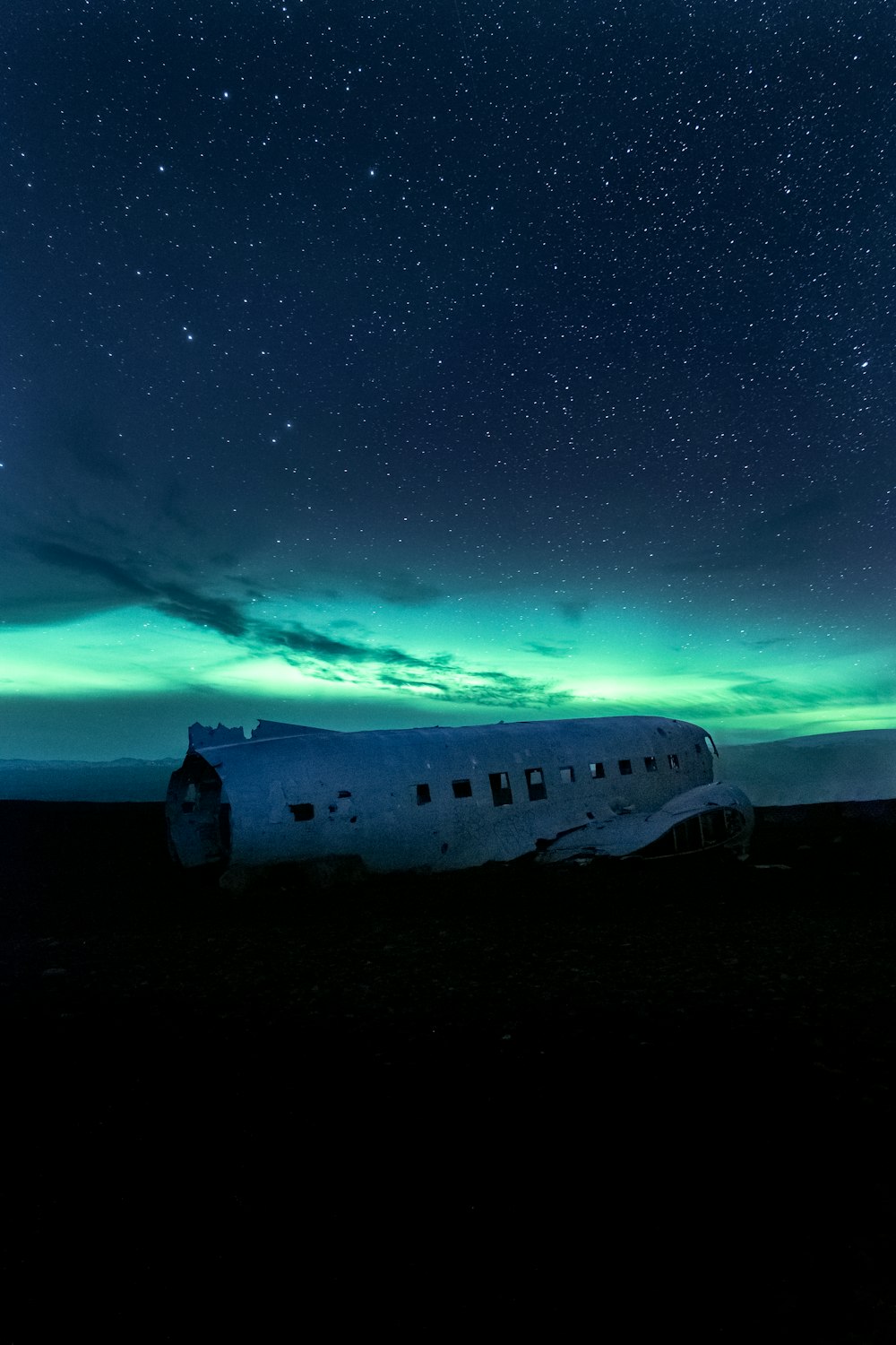 Un avion assis au milieu d’un champ sous un ciel nocturne