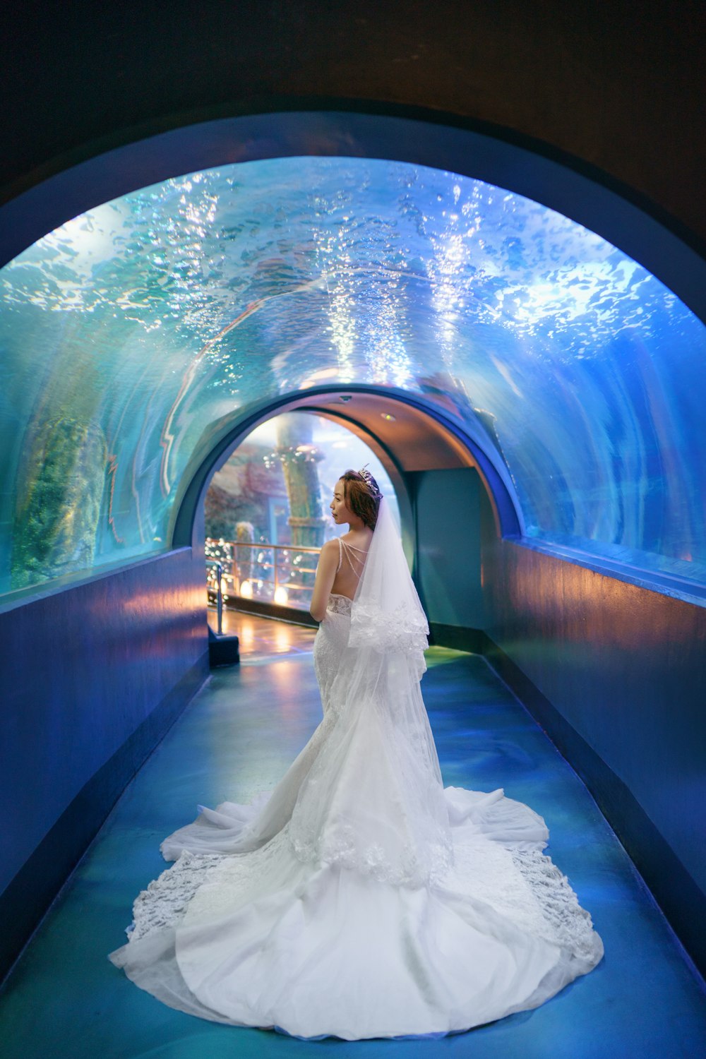 a woman in a wedding dress standing in a tunnel