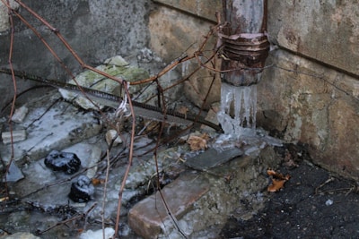 a fire hydrant next to a wall with ice on it