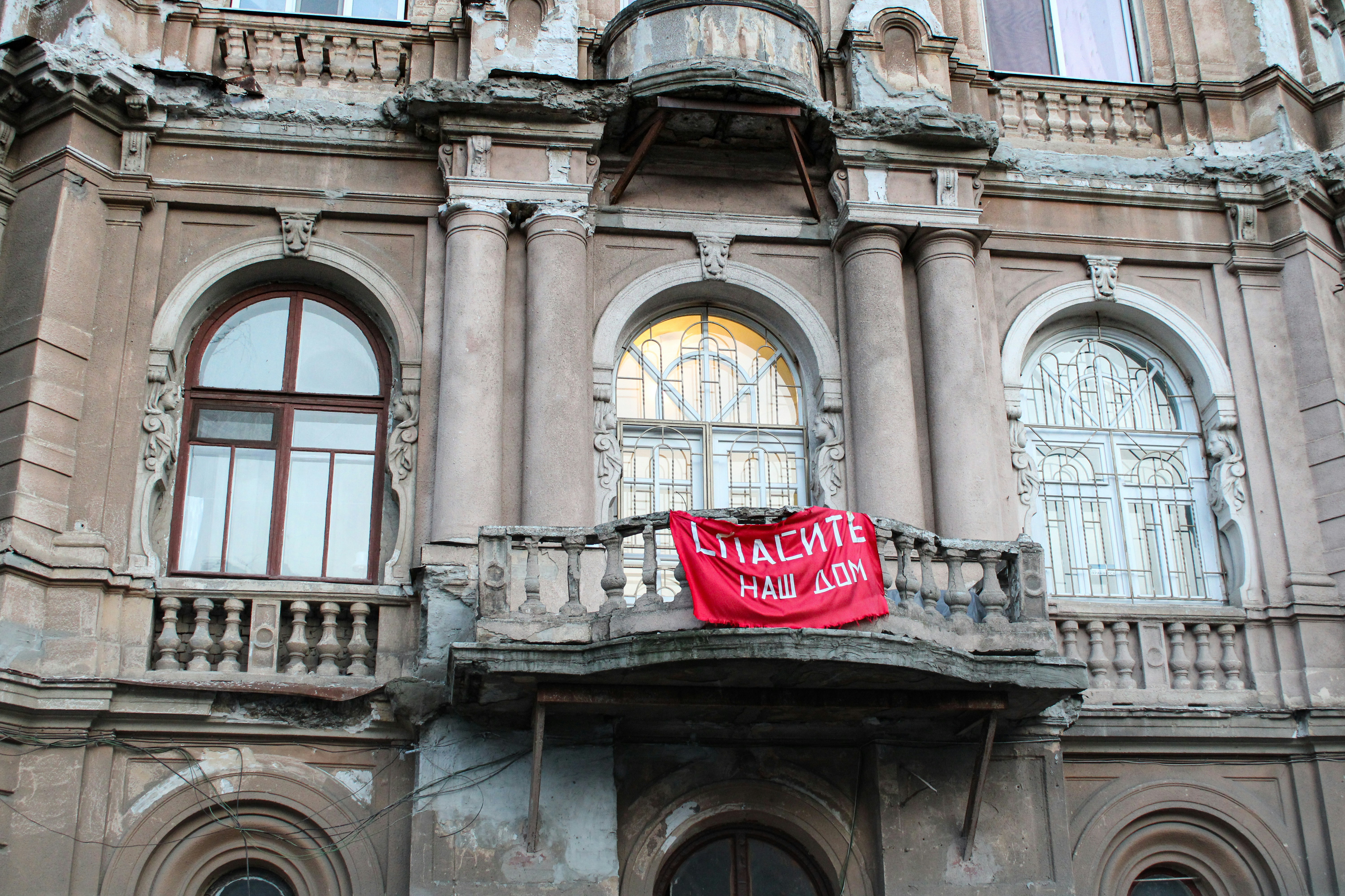 A group of citizens holding placards protesting outside a historical building, advocating for its preservation