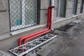 a red pipe on the side of a building