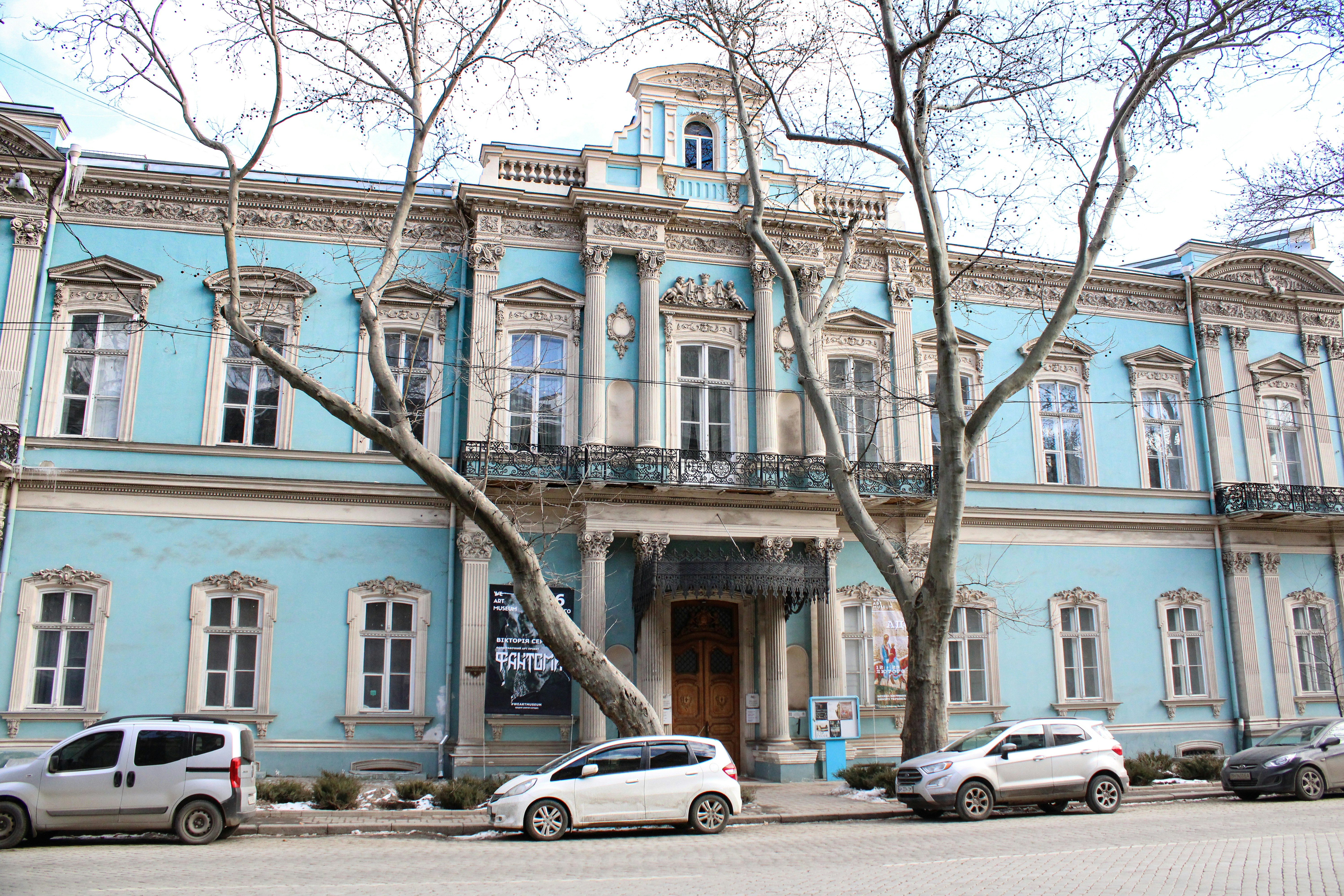 a blue building with many cars parked in front of it