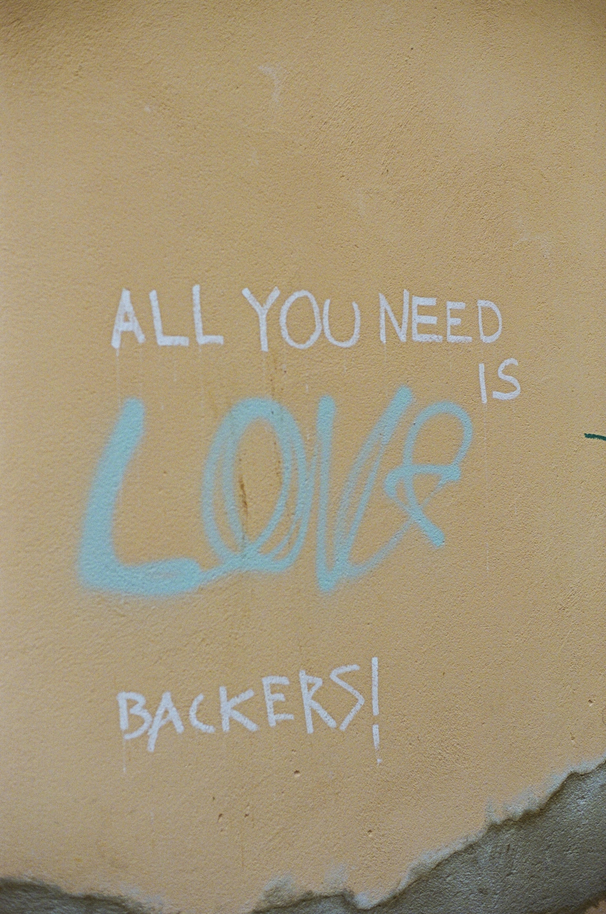 Graffiti an der Seite eines Gebäudes, das sagt, dass alles, was Sie brauchen, Liebe und Rucksack ist
