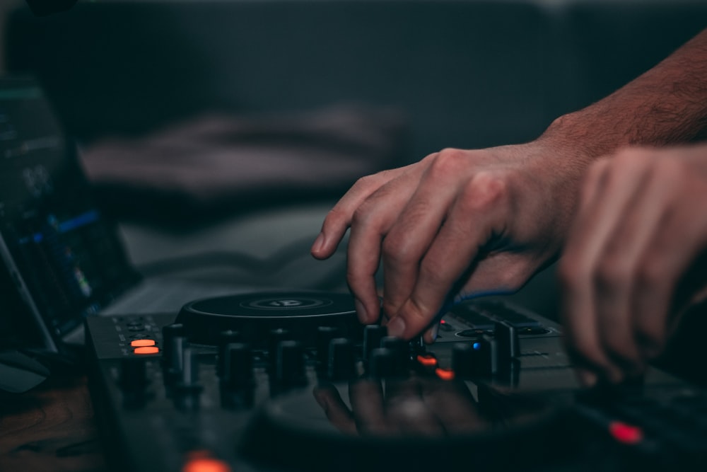 a person using a dj controller in front of a laptop