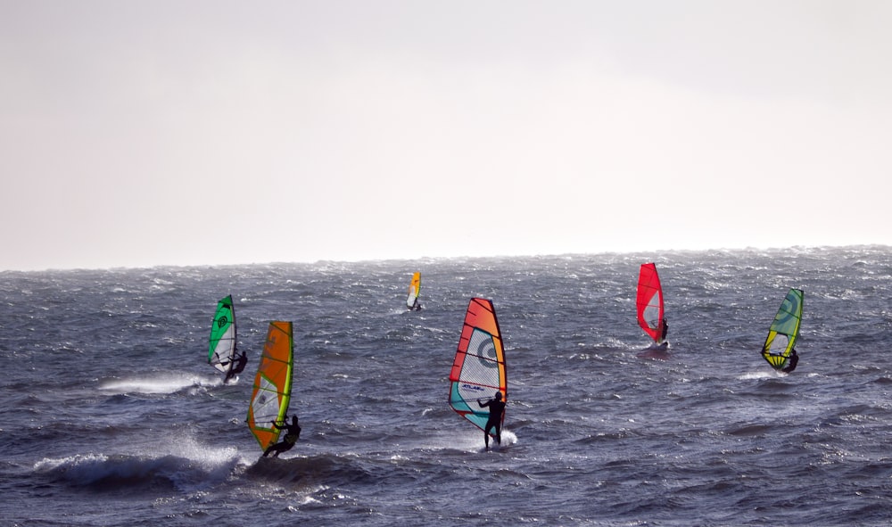 a group of people wind surfing in the ocean