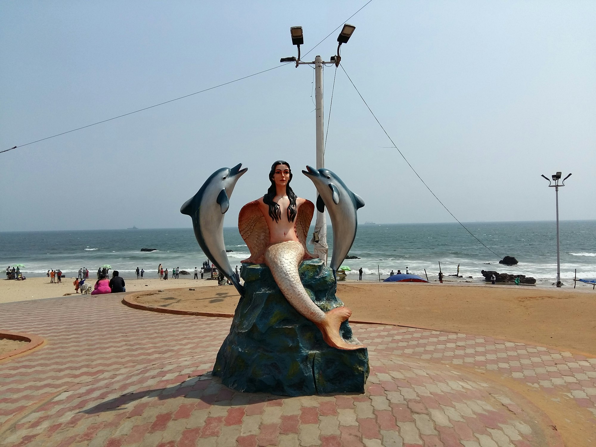 Mermaid with Dolphins Sculpture
RK Beach, also known as Ramakrishna Beach is an integral part of the city and a favorite among Vizagites and Tourists alike. The view of the sunrise from this beach is truly mesmerizing and one can find a number of people enjoying, some relaxed moments in this beautiful beach enjoying the perfect view. This 3 km stretch, kissed by the sea & ships on one side and flanked by multi-colored apartments on the other makes for a truly rewarding drive. The entire stretch is dotted with beach food snacks.