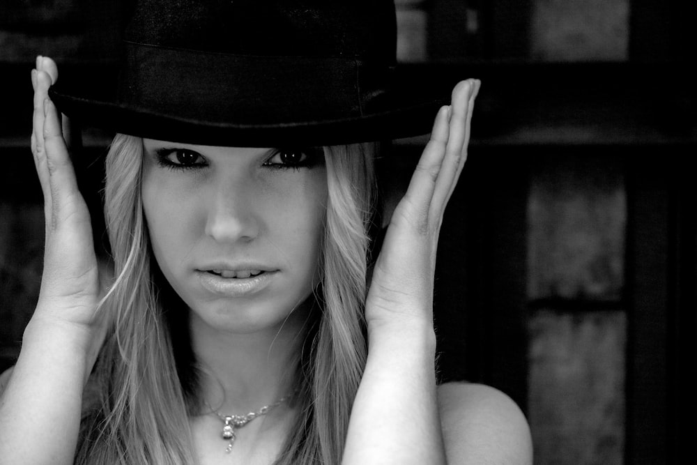 a woman wearing a hat and posing for a picture