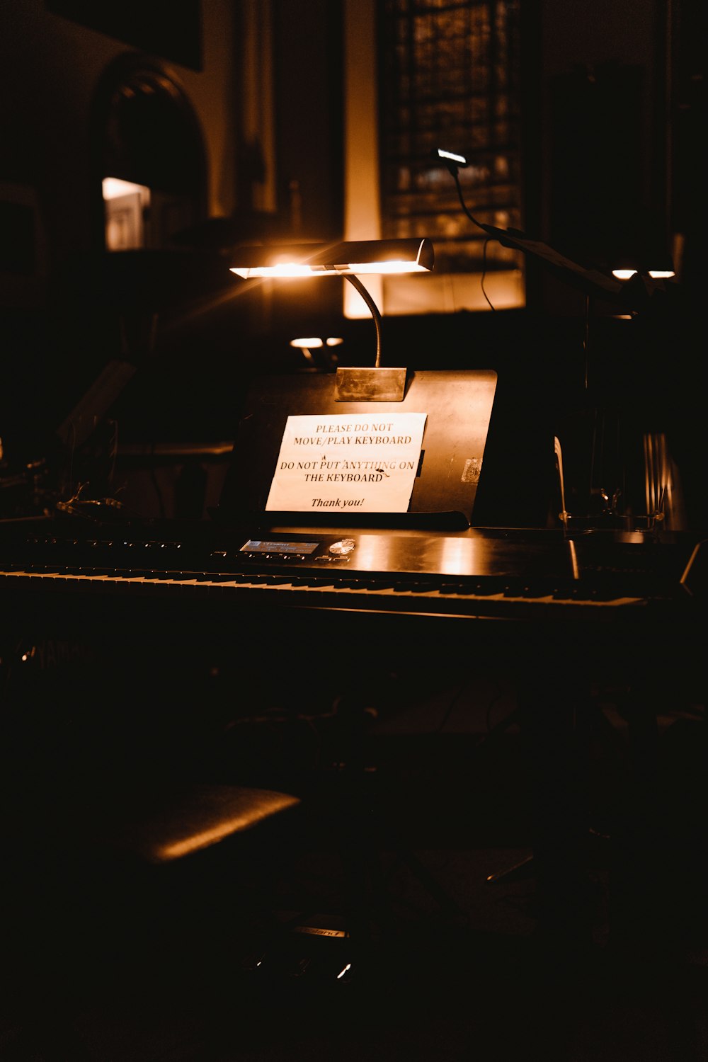 a piano with a note attached to it in a dark room