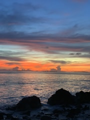 A serene painting of a sunset over a calm ocean, showcasing artistic talent.