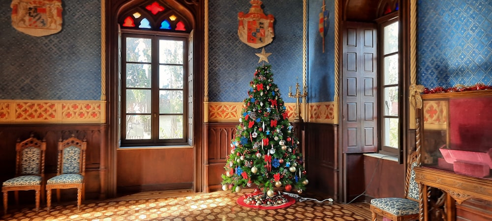 a decorated christmas tree in a room with blue walls