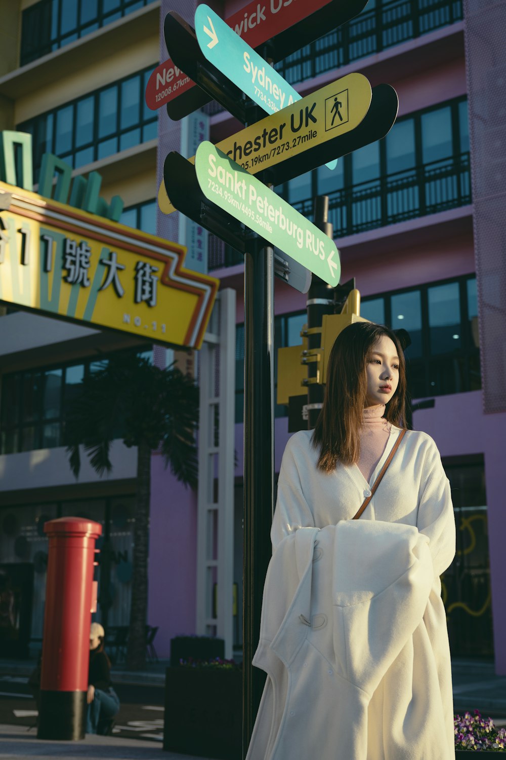 a woman standing next to a street sign