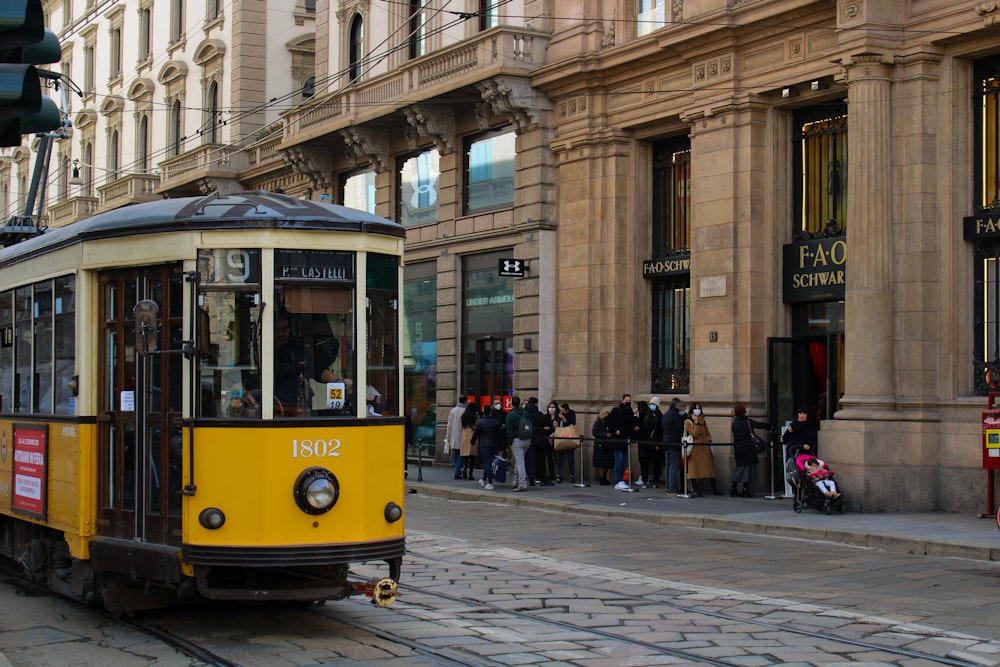 a yellow and black trolley on a city street