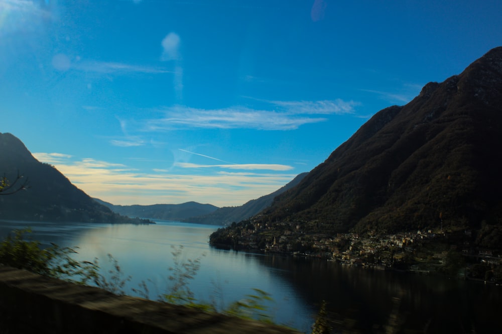 a view of a lake and mountains from a train