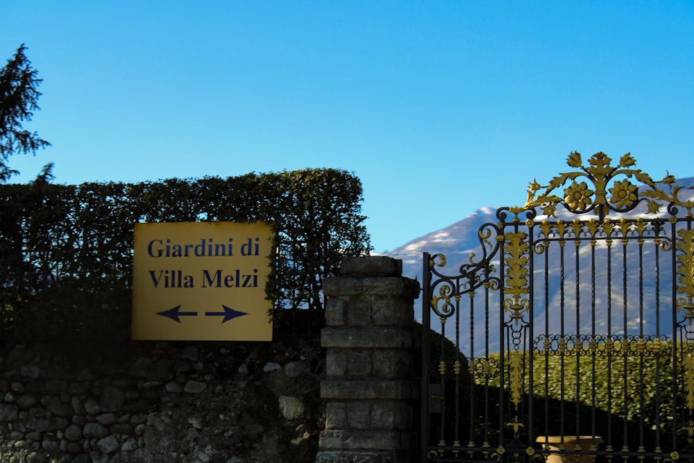 a gate with a sign that says guardini di villa melzi