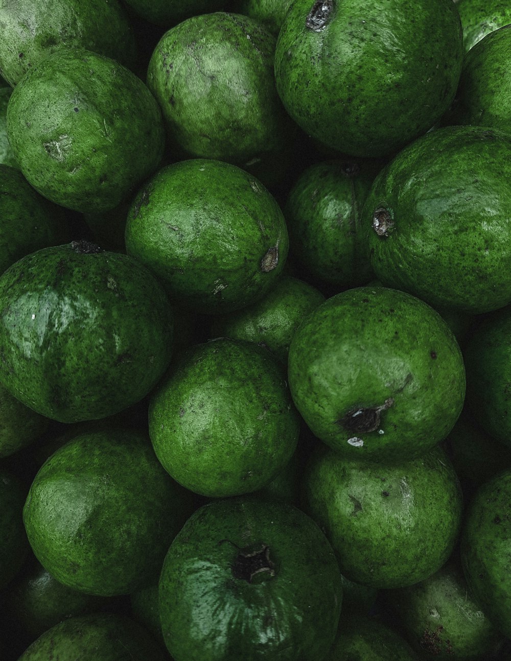 a pile of green fruit sitting on top of each other
