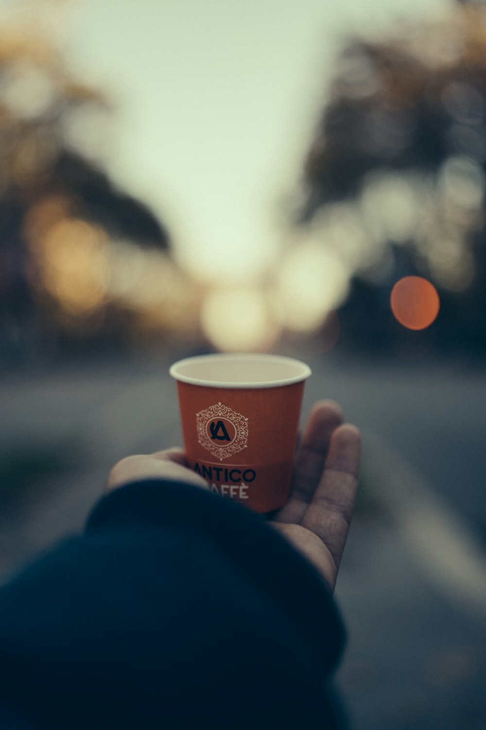 a person holding a cup of coffee in their hand