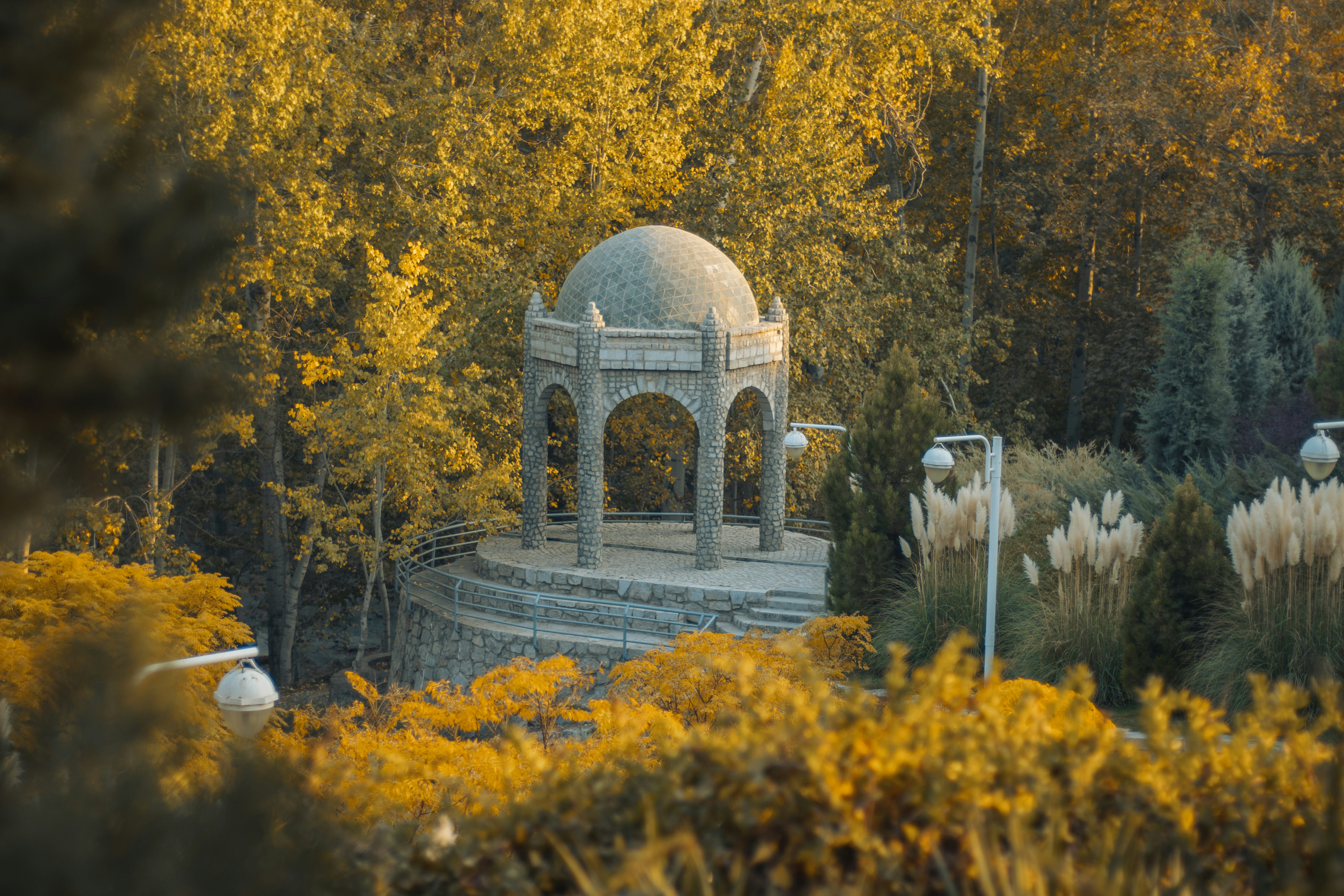 a gazebo in the middle of a park surrounded by trees