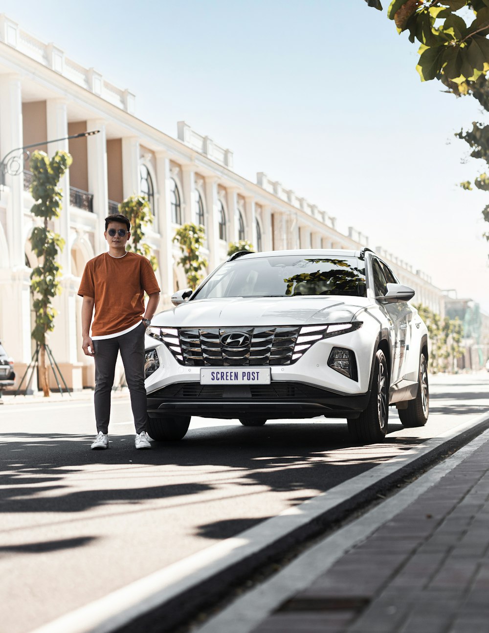 a man standing next to a white car