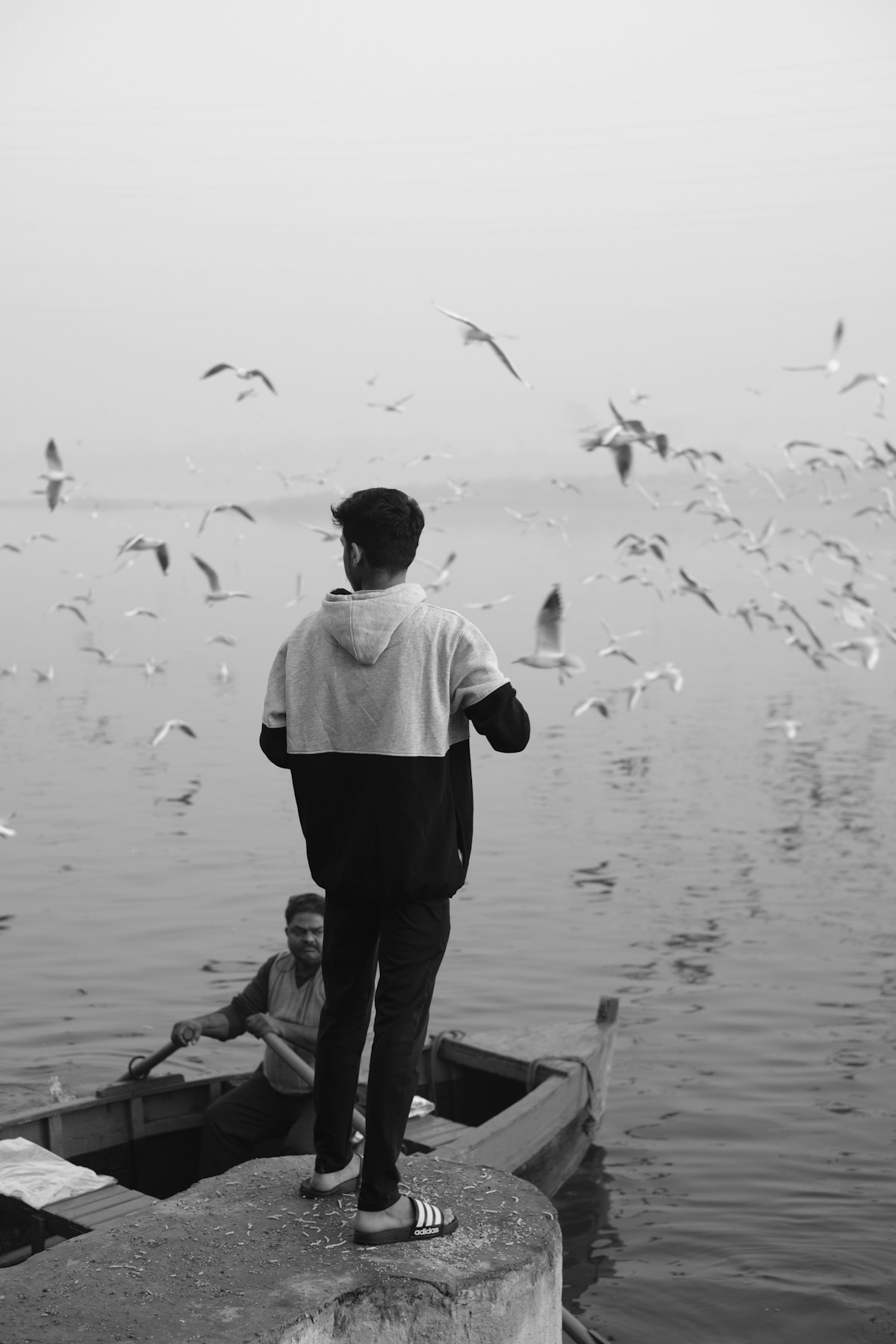 A man standing on the edge of a boat on the Yamuna river